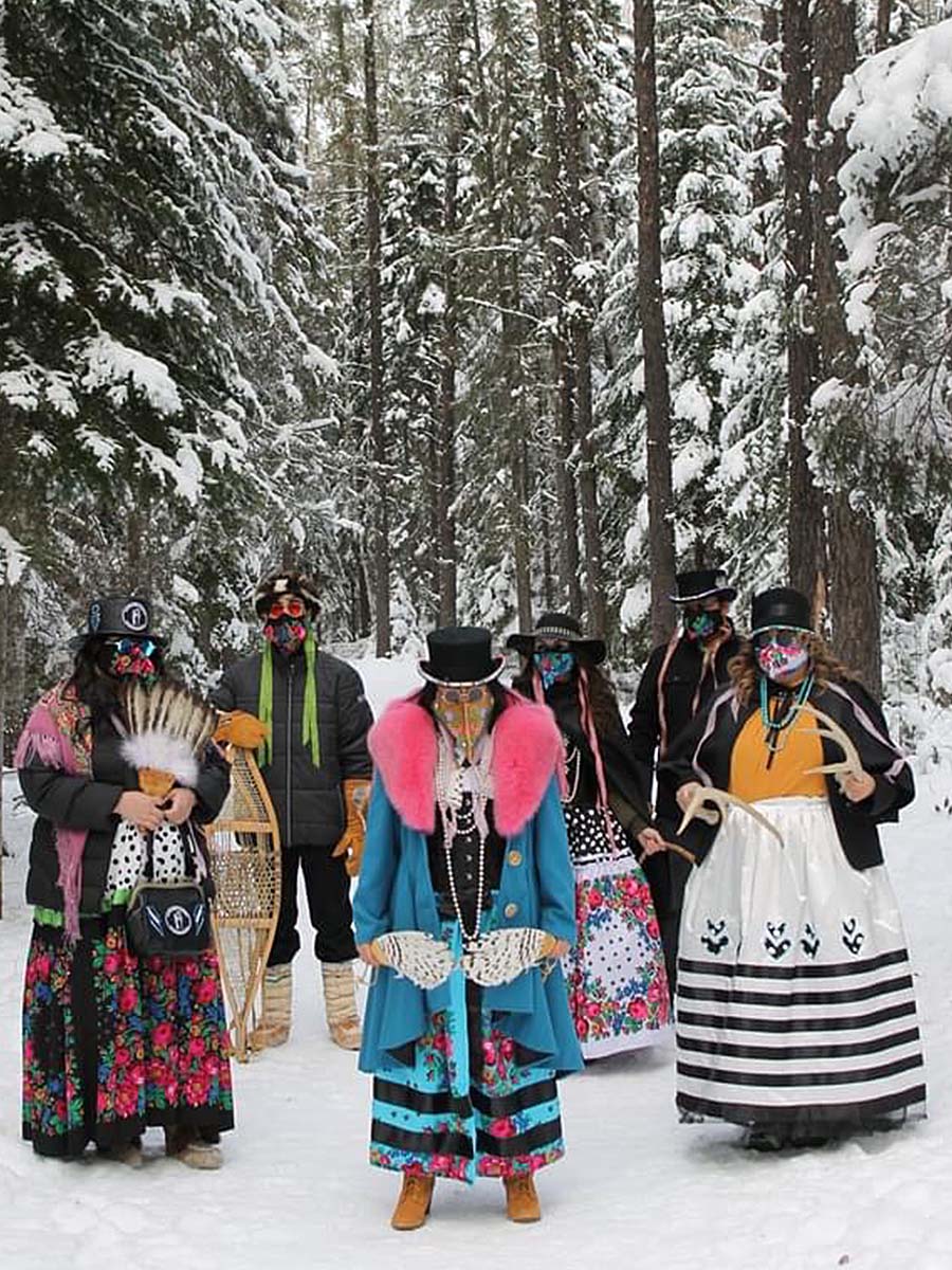 6 people wearing beaded plague doctor face masks in a forest
